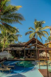 a resort with palm trees and a swimming pool at Aloha Village Hotel in Icaraí