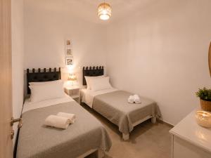 a room with two beds with towels on them at Our Kea apartment in Otziás