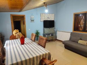 a living room with a table and a couch and a tv at Casa Alcántara in Vilamelle