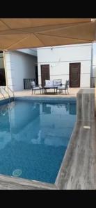 a large swimming pool with a table and a bench at Ras Al Hadd's bounty in Sur