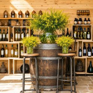 a room with two stools and a barrel with flowers on it at Laklouk 1808 Lodge by Hansa in ‘Ayn aş Şalīb