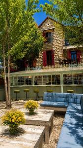 a building with a blue couch and tables in a yard at Laklouk 1808 Lodge by Hansa in ‘Ayn aş Şalīb