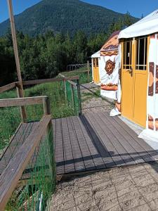 a wooden boardwalk leading to a building in a field at mountain glambing in Tappen