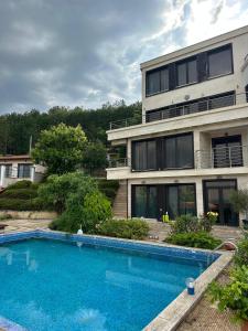 a house with a swimming pool in front of it at The Shefers Residence in Rogachevo