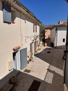 an alley with a white building and a street at Le Petit Nid de Venelles in Venelles