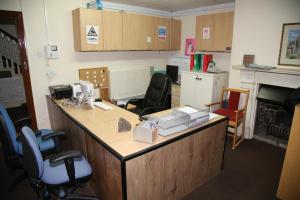 una oficina con escritorio con sillas y chimenea en A Gosport Inn, en Gosport