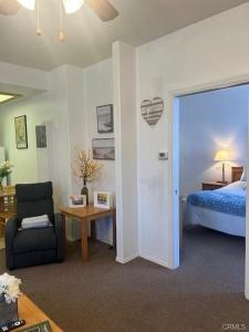 a room with a bedroom with a bed and a chair at The Cottage on the Coast in Oceano