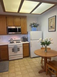 a kitchen with a white refrigerator and a table at The Cottage on the Coast in Oceano