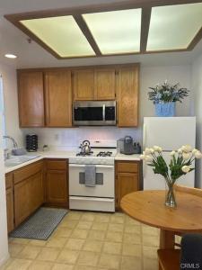 a kitchen with a stove and a refrigerator and a table at The Cottage on the Coast in Oceano