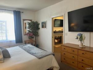 a bedroom with a bed and a television and a dresser at The Cottage on the Coast in Oceano +7 photos
