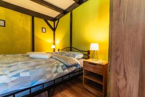 a bedroom with yellow walls and a bed and a nightstand at Dedekov gaj in Oteš