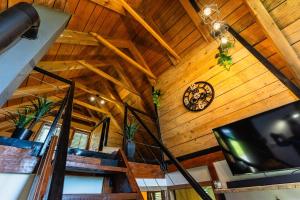 a living room with a clock on a wooden ceiling at Dedekov gaj in Oteš