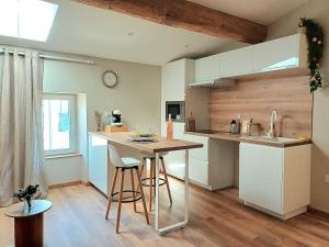 a kitchen with a counter and a table with stools at Studio cosy Le3bis proche Cap d'Agde in Bessan
