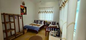 a small room with a bed and a bed and a table at Equalia boutique hotel in Jambiani