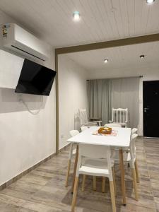 a dining room with a white table and chairs at Complejo San Carlos in General Acha