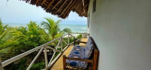 a room with a balcony with a view of the ocean at Equalia boutique hotel in Jambiani