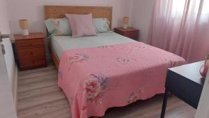a bedroom with a pink bed with a pink blanket at Casa Alentejana in Mora