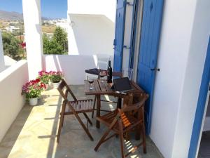 a table and chairs on a balcony with a laptop at Thalia Apartment in Piso Livadi