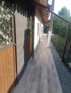a hallway leading to a building with a wooden door at Irina Holiday House in Mangalia