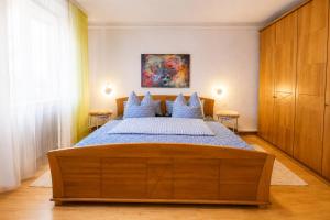 a bedroom with a large bed with blue pillows at Lange Hans Rennsteig in Oberschönau