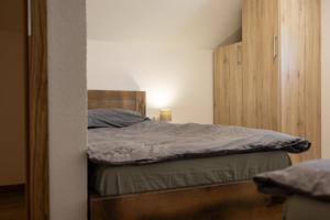 a bedroom with a bed and a wooden cabinet at Holiday House Štrbački buk in Donji Lapac