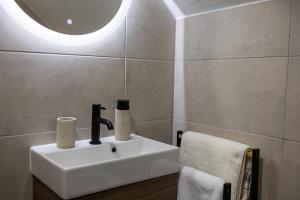 a bathroom with a white sink and a mirror at Holiday House Štrbački buk in Donji Lapac +34 photos
