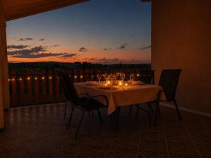 a table with wine glasses and candles on a balcony at Vinea Apartma in Gornja Radgona