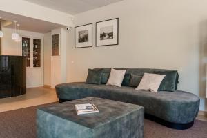 a living room with a couch and two ottoman at Cova da Iria Hotel in Fátima