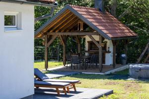 a pavilion with a table and chairs in a yard at Holiday House Štrbački buk in Donji Lapac