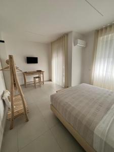 a bedroom with a bed and a table and a television at Mamma mia rooms in Nola
