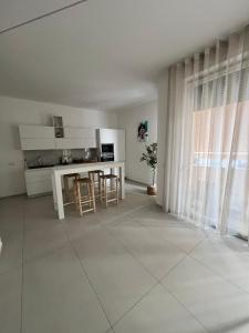 a white kitchen with a table and chairs in it at Mamma mia rooms in Nola