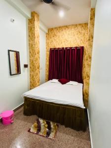 a bedroom with a bed with a red curtain at Dhanwantri Niwas in Varanasi
