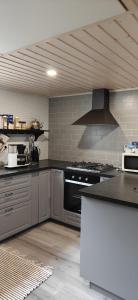 a kitchen with stainless steel appliances and a stove at Raju - Guest House in Seinäjoki