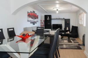 a dining room and living room with a glass table at Casa Borboleta in Arco da Calheta