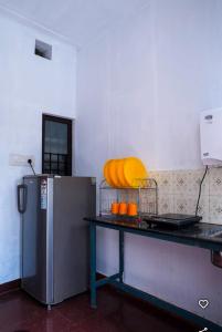 a kitchen with a table with oranges and a refrigerator at New Jtr Residency in Ernakulam +8 photos
