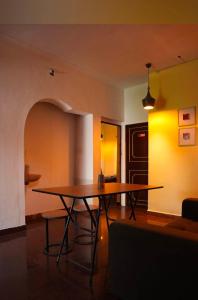 a dining room with a table and a yellow wall at New Jtr Residency in Ernakulam