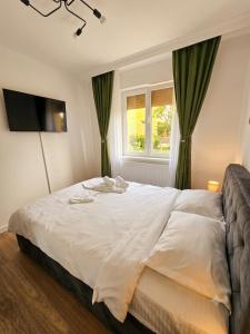 a bedroom with a large white bed with a window at Cozy green apartament in Mediaş