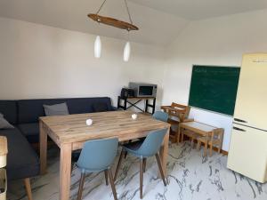 a living room with a wooden table and blue chairs at Ferienwohnung Pieck in Raduhn