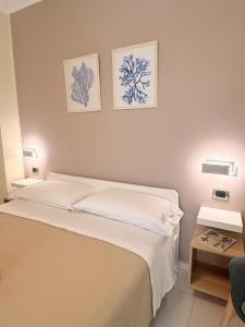 a bedroom with a bed and two pictures on the wall at Perla Marina B&B in Nicotera Marina