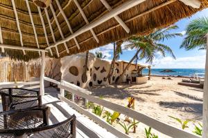 a view of the beach from the porch of a beach house at Hotel Qamar in Tulum