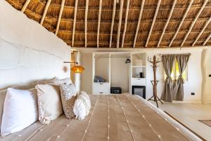 a bedroom with a large bed with white pillows at Hotel Qamar in Tulum