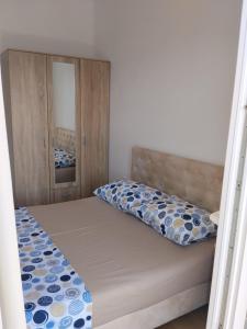 a small bedroom with a bed and a mirror at Apartman Vesna in Budva