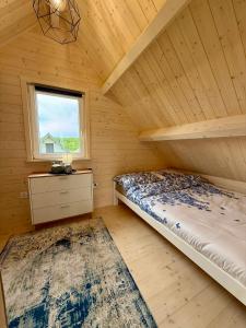 a bedroom with a bed and a window in a cabin at Osada Mielenko in Mielenko
