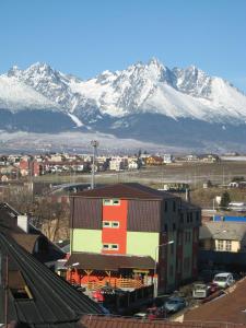 una ciudad con montañas cubiertas de nieve en el fondo en Penzión Slávia, en Poprad