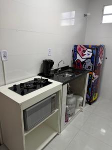 a white kitchen with a stove and a sink at Hostel do moreno in Vila Velha