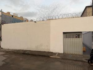 a white building with a door and a fence at Hostel do moreno in Vila Velha