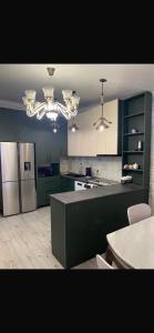 a kitchen with green cabinets and a refrigerator at NikO's Stay in Mestia