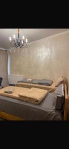 a bedroom with two beds and a chandelier at NikO's Stay in Mestia