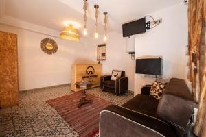a living room with a couch and a tv at Waves Hunter Surf House in Agadir