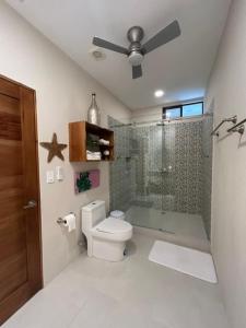 a bathroom with a toilet and a glass shower at Sal y Sol in Quepos